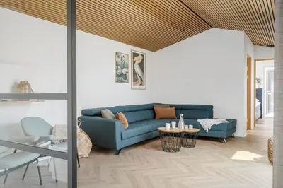 a living room with a blue couch and a table at 265-Harboore-Lucievej-6-b in Harboør