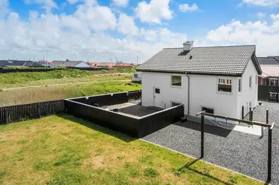 a small white house in a field with a yard at 705-Thyboron-Romovej-7 in Thyborøn