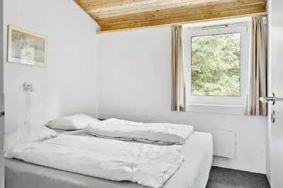 two beds in a white room with a window at 203-Harboore-Viktoriavej-3 in Harboør