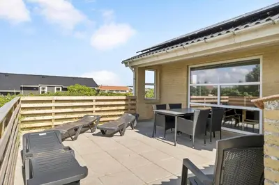 a patio with chairs and a table and a fence at 203-Harboore-Viktoriavej-3 in Harboør