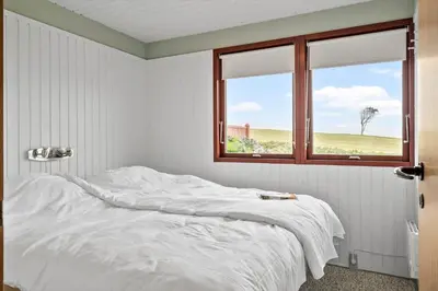 a white bedroom with a bed and a window at G431-Lemvig-Gyvelvej-31 in Lemvig