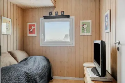 a bedroom with a bed and a tv and a window at 123-Harboore-Vejlby-Klit-83 in Harboør
