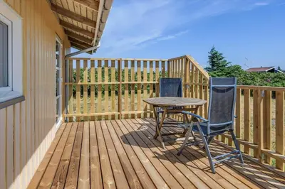 a patio with a table and two chairs on a deck at 123-Harboore-Vejlby-Klit-83 in Harboør
