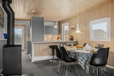 a kitchen with a table with chairs and a stove at 123-Harboore-Vejlby-Klit-83 in Harboør