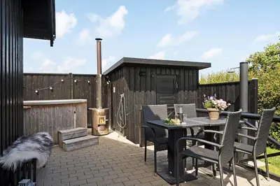 a patio with a table and chairs and a grill at G245-Lemvig-Porsevej-45 in Lemvig
