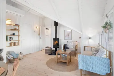 a living room with a fireplace and a table and chairs at 254-Harboore-Vejlby-Klit-251 in Harboør