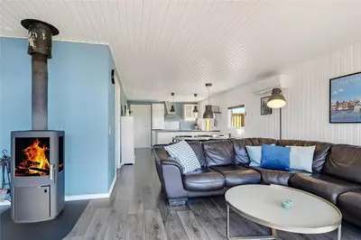 a living room with a leather couch and a fireplace at 235-Harboore-Vejlby-Klit-139 in Harboør