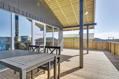 a patio with a wooden table and chairs on a deck at 235-Harboore-Vejlby-Klit-139 in Harboør