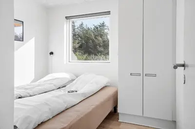 a white room with two beds and a window at 362-Harboore-Gloryvej-6 in Harboør