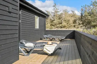 a wooden deck with two chairs and a table at 362-Harboore-Gloryvej-6 in Harboør