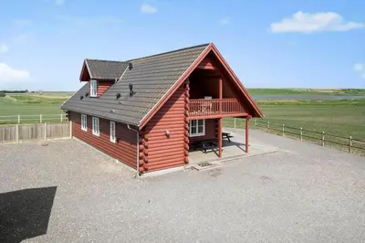 a log cabin with a balcony and a porch at 289-Harboore-Strandvejen-179 in Harboør