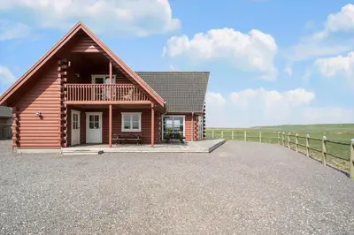 a log cabin with a porch and a fence at 289-Harboore-Strandvejen-179 in Harboør