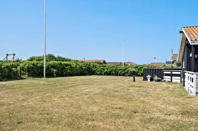 a large yard next to a house with a fence at 111-Harboore-Vejlby-Klit-125 in Harboør