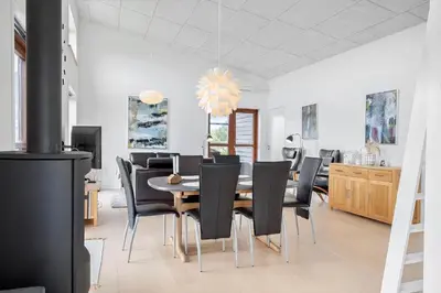 a dining room with a table and black chairs at G161-Lemvig-Porsevej-61 in Lemvig