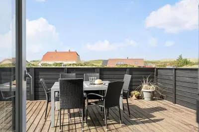 a patio with a table and chairs on a deck at 225-Harboore-Neerlandiavej-268 in Harboør