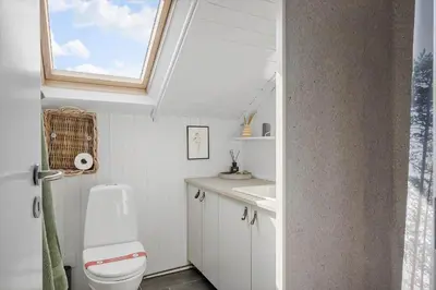a bathroom with a toilet and a sink and a window at 225-Harboore-Neerlandiavej-268 in Harboør