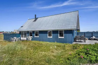 a blue house sitting on top of a field at 301-Harboore-Themisvej-11 in Harboør