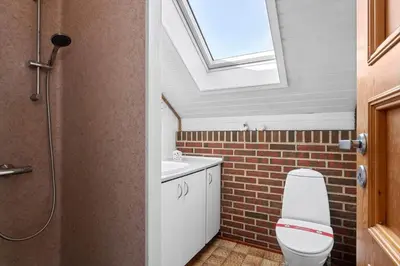 a bathroom with a toilet and a skylight at G149-Lemvig-Porsevej-49 in Lemvig