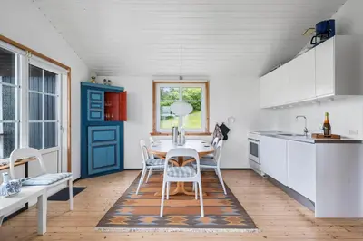 a kitchen with a table and chairs and a blue door at G398-Lemvig-Violvej-98 in Lemvig