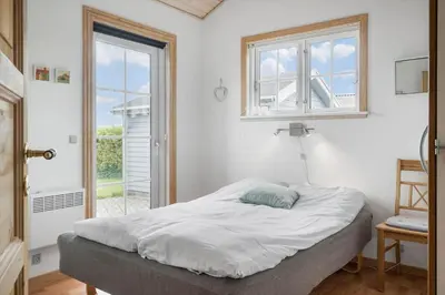 a bedroom with a bed and a window and a door at G287-Lemvig-Bellisvej-87 in Lemvig