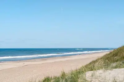 a sandy beach with the ocean in the background at 251-Harboore-Neerlandiavej-230 in Harboør