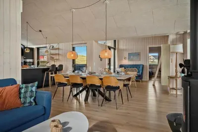 a dining room and living room with a table and chairs at 332-Harboore-Hvilehjemsvej-20 in Harboør