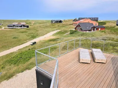 two benches on a deck with houses in the background at 257-Harboore-Dalevej-8 in Harboør