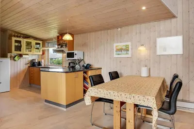 a kitchen and dining room with a table and chairs at G129-Lemvig-Gjelleroddevej-129 in Lemvig