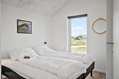 a white bedroom with a large bed with a window at 272-Harboore-Neerlandiavej-196 in Harboør
