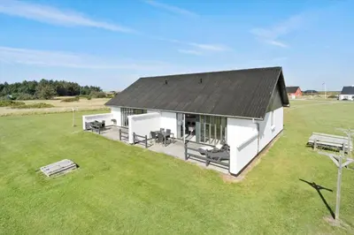 a white building with a black roof in a field at 114-Harboore-Strandvejen-164 in Harboør
