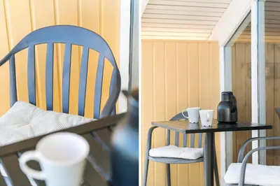 a chair and a table with cups on a balcony at 127-Harboore-Vejlby-Klit-237 in Harboør