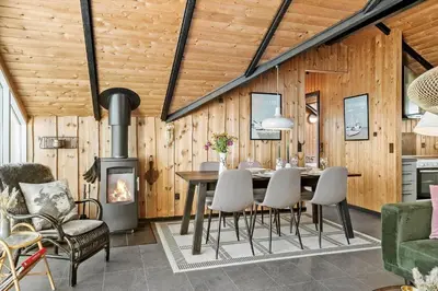 a dining room with a table and a fireplace at 127-Harboore-Vejlby-Klit-237 in Harboør
