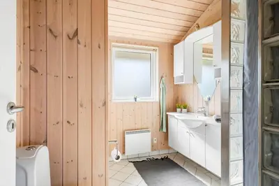 a bathroom with a sink and a toilet and a window at 104-Harboore-Neerlandiavej-29 in Harboør