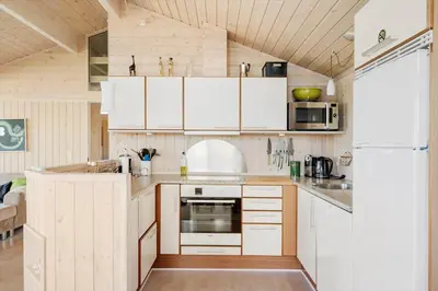 a kitchen with white cabinets and a refrigerator at 104-Harboore-Neerlandiavej-29 in Harboør