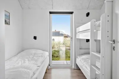 a bedroom with two bunk beds and a window at 252-Harboore-Amazonevej-6 in Harboør