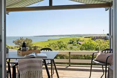 a table and chairs on a balcony with a view of the ocean at G319-Lemvig-Violvej-19 in Lemvig