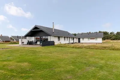 a white house with a large yard in front of it at 112-Harboore-Nautilusvej-1-c in Harboør