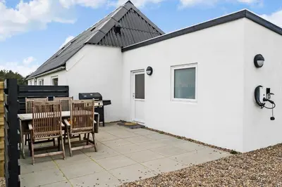 a white building with two chairs and a table at 370-Harboore-Strandvejen-53 in Harboør