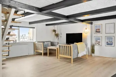 a living room with a table and a couch and a television at 370-Harboore-Strandvejen-53 in Harboør