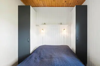 a bedroom with a bed with a blue blanket at 182-Harboore-Vejlby-Klit-153-a in Harboør