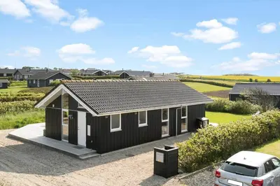 a black house with a car parked in front of it at G126-Lemvig-Bynkevej-26 in Lemvig