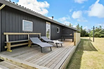 a wooden deck with two benches on a house at 204-Harboore-Vejlby-Klit-33 in Harboør