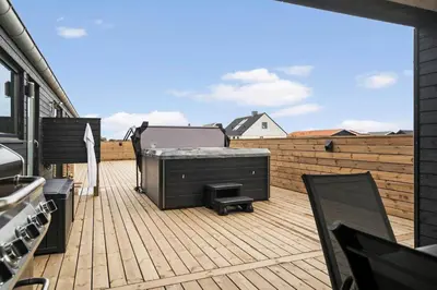 a balcony with a grill on a wooden deck at 368-Harboore-Gloryvej-25 in Harboør