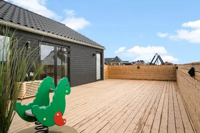 a patio with a dinosaur painted on the side of a house at 368-Harboore-Gloryvej-25 in Harboør