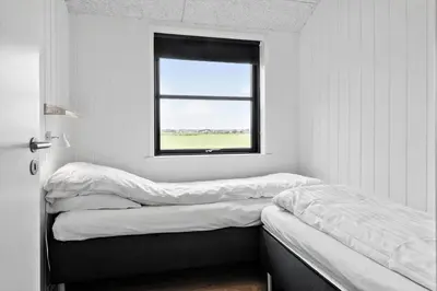 a room with three beds and a window at 260-Harboore-Strandvejen-158-C in Harboør