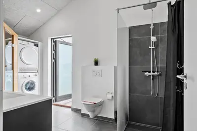 a bathroom with a toilet and a washing machine at 260-Harboore-Strandvejen-158-C in Harboør