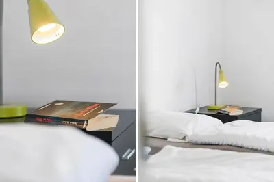 a bedroom with a bed and a table with a lamp at 148-Harboore-Lucievej-6-a in Harboør