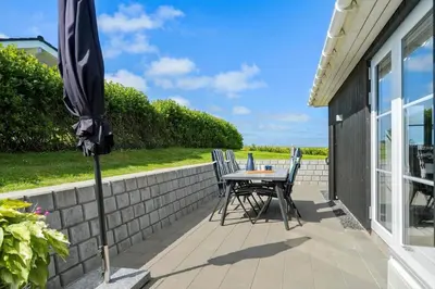 a patio with an umbrella and a table and chairs at G509-Lemvig-Myntevej-9 in Lemvig