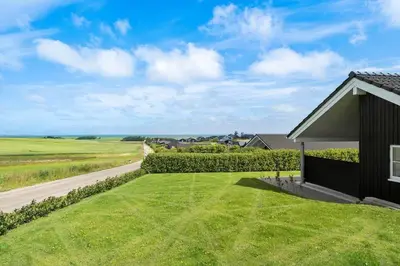 a house with a grassy yard next to a road at G509-Lemvig-Myntevej-9 in Lemvig