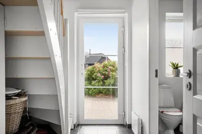 a bathroom with a toilet and a door with a window at 324-Harboore-Skalvej-4-b in Harboør